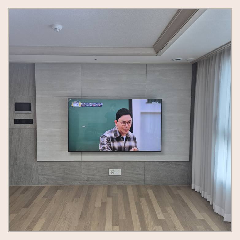 벽걸이TV 설치 사진 - 벽면에 걸린 TV와 창가 쪽 간격