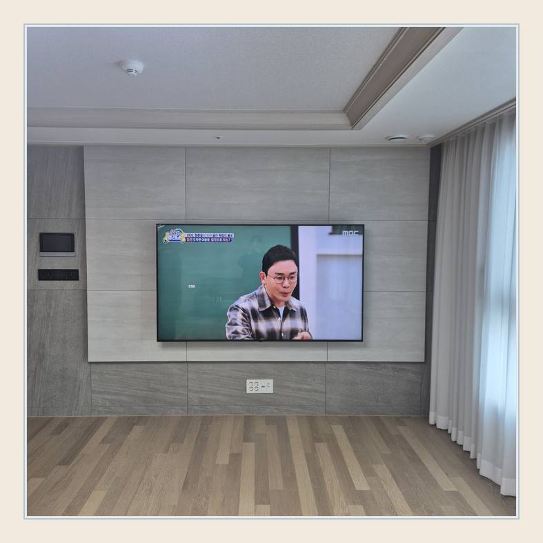 벽걸이TV 설치 사진 - 벽면에 걸린 TV와 창가 쪽 간격