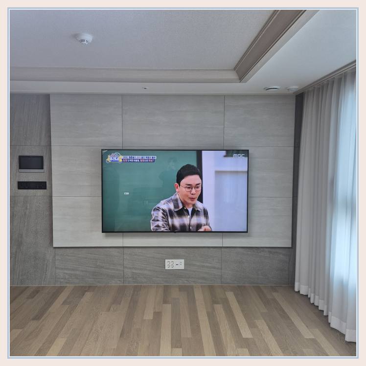벽걸이TV 설치 사진 - 벽면에 걸린 TV와 창가 쪽 간격
