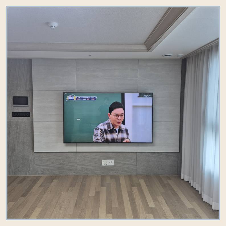 벽걸이TV 설치 사진 - 벽면에 걸린 TV와 창가 쪽 간격