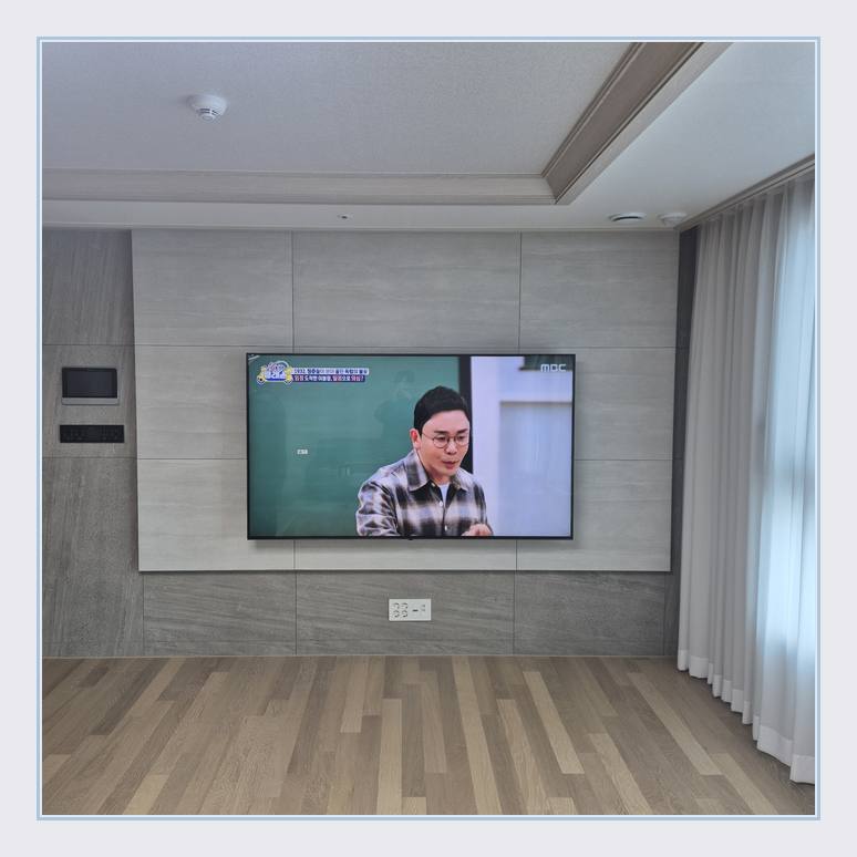 벽걸이TV 설치 사진 - 벽면에 걸린 TV와 창가 쪽 간격