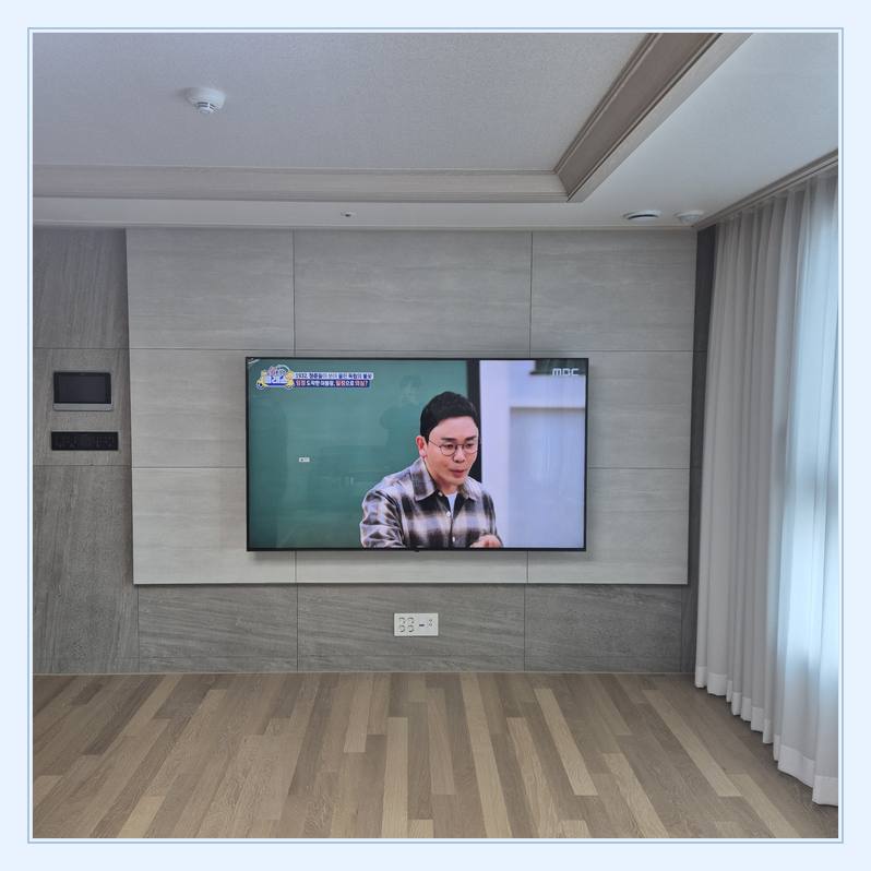 벽걸이TV 설치 사진 - 벽면에 걸린 TV와 창가 쪽 간격