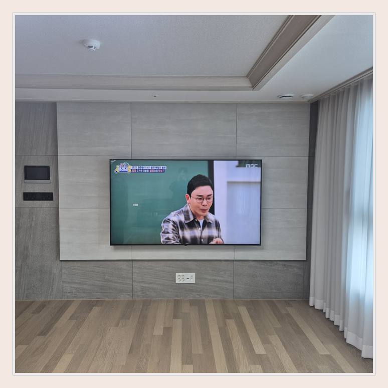 벽걸이TV 설치 사진 - 벽면에 걸린 TV와 창가 쪽 간격