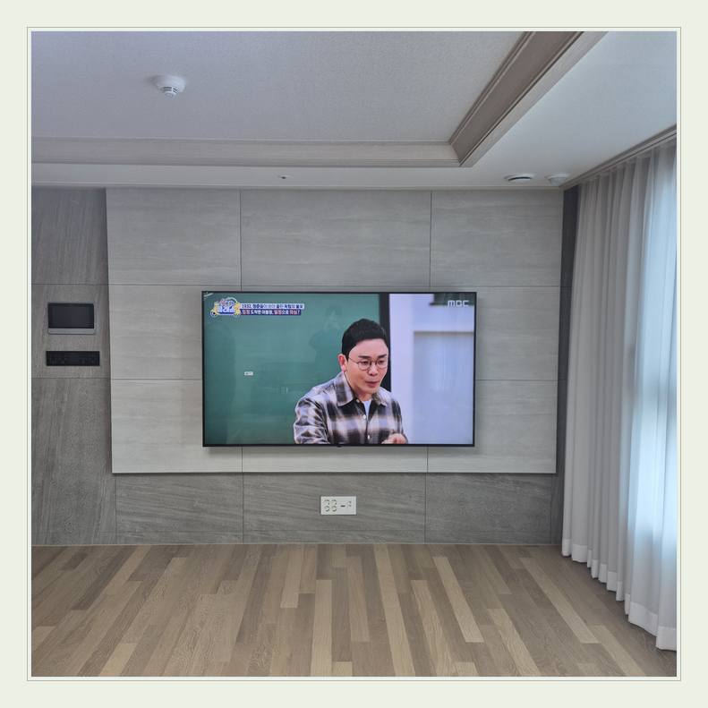 벽걸이TV 설치 사진 - 벽면에 걸린 TV와 창가 쪽 간격