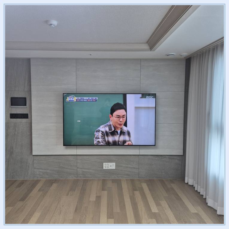 벽걸이TV 설치 사진 - 벽면에 걸린 TV와 창가 쪽 간격